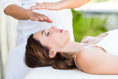  receiving reiki treatment in the health spa